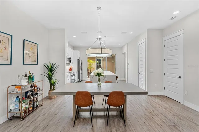 a dining room with furniture potted plants and wooden floor