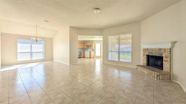 a view of an empty room with a fireplace and a window