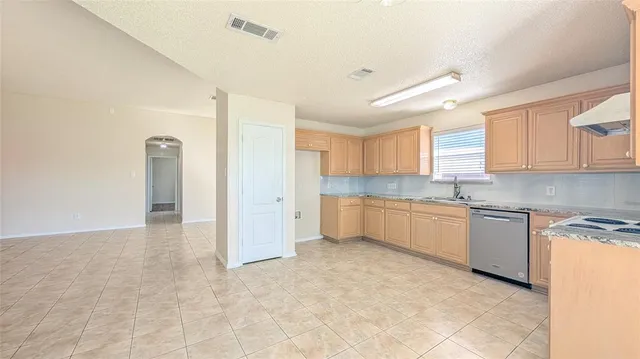a large kitchen with a refrigerator and white cabinets