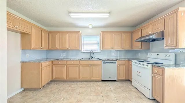 a kitchen with cabinets appliances a sink and a window