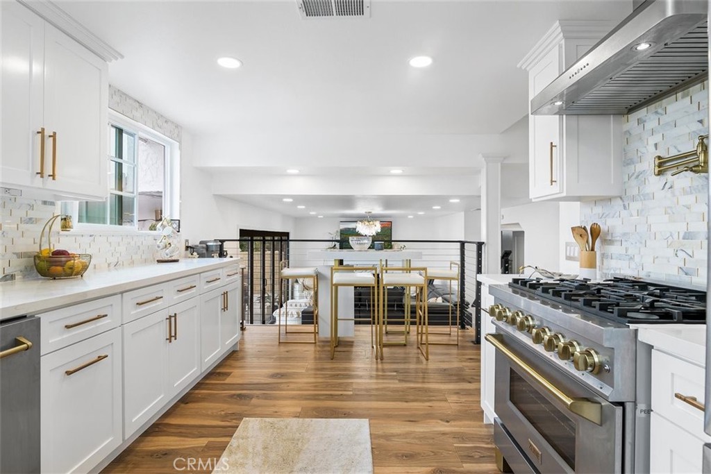 1216 Baseline Road La Verne, CA 91750 - Photo 12 of 37 a kitchen with stainless steel appliances granite countertop a stove top oven a sink dishwasher and white cabinets with wooden floor