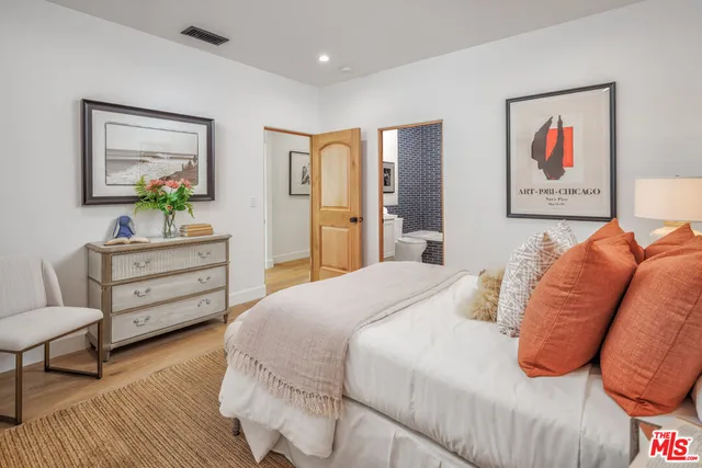 a spacious bedroom with a bed and wooden floor