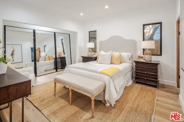 a bedroom with furniture and a painting on the wall