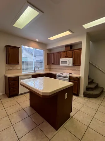 a kitchen with stainless steel appliances granite countertop a stove a sink and a microwave