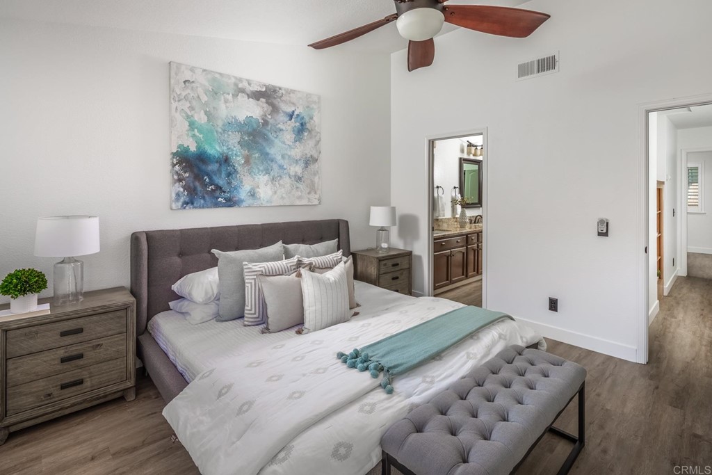 7777 Caminito Monarca, Unit 105 Carlsbad, CA 92009 - Photo 13 of 25 a bedroom with a bed and wooden floor