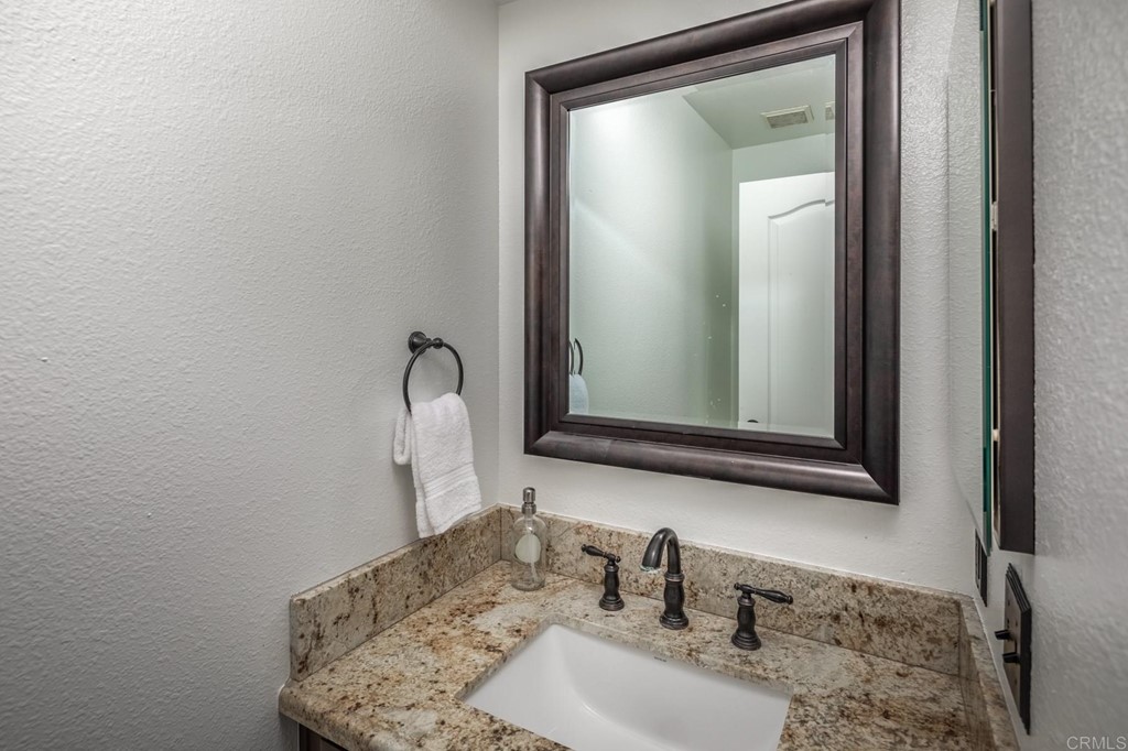 7777 Caminito Monarca, Unit 105 Carlsbad, CA 92009 - Photo 10 of 25 a bathroom with a sink and a mirror