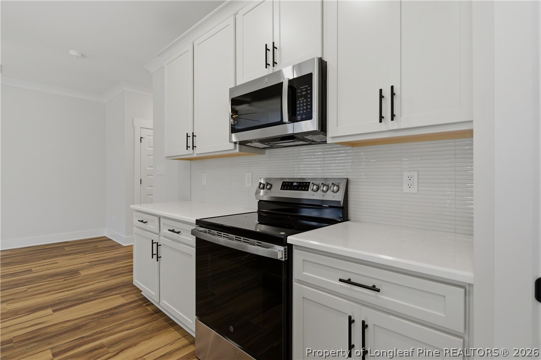 3931 Hamilton Street Hope Mills, NC 28348 - Photo 25 of 50 a kitchen with stainless steel appliances a stove microwave and cabinets