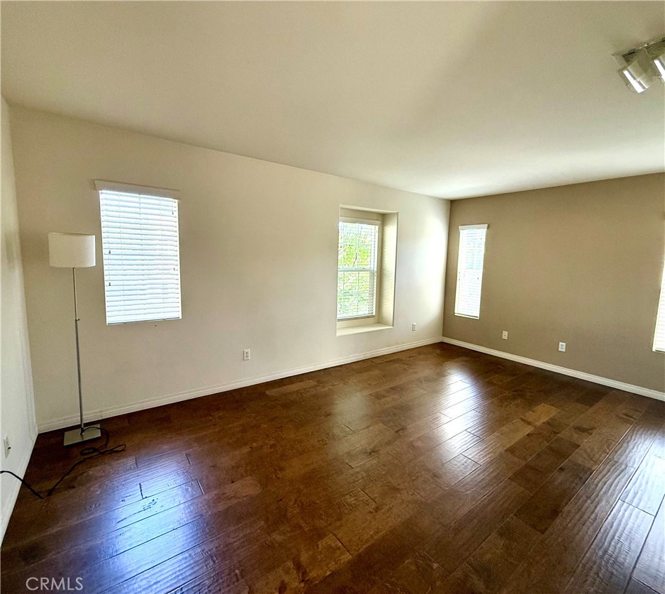 14540 Manchester Avenue Chino, CA 91710 - Photo 11 of 22 an empty room with wooden floor and windows