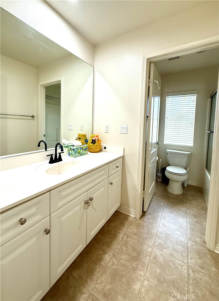 14540 Manchester Avenue Chino, CA 91710 - Photo 18 of 22 a spacious bathroom with a double vanity sink a toilet and a mirror
