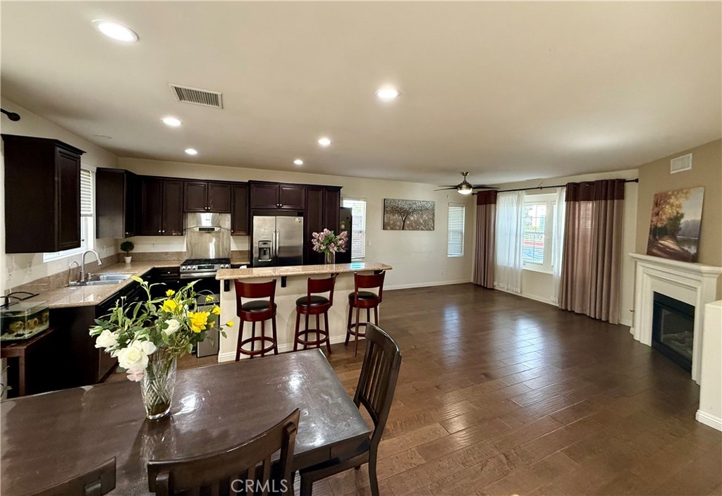 14540 Manchester Avenue Chino, CA 91710 - Photo 6 of 22 a kitchen with stainless steel appliances granite countertop a refrigerator a sink dishwasher a dining table and chairs with wooden floor