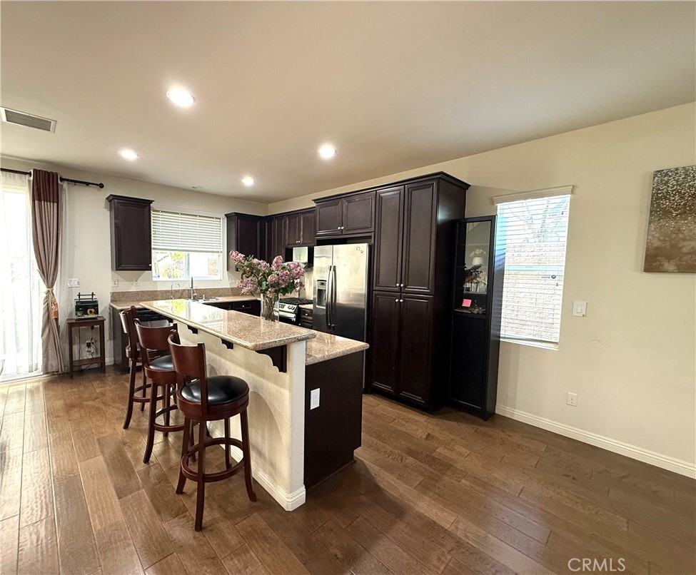 14540 Manchester Avenue Chino, CA 91710 - Photo 9 of 22 a kitchen with stainless steel appliances granite countertop a refrigerator a sink a stove a dining table and chairs