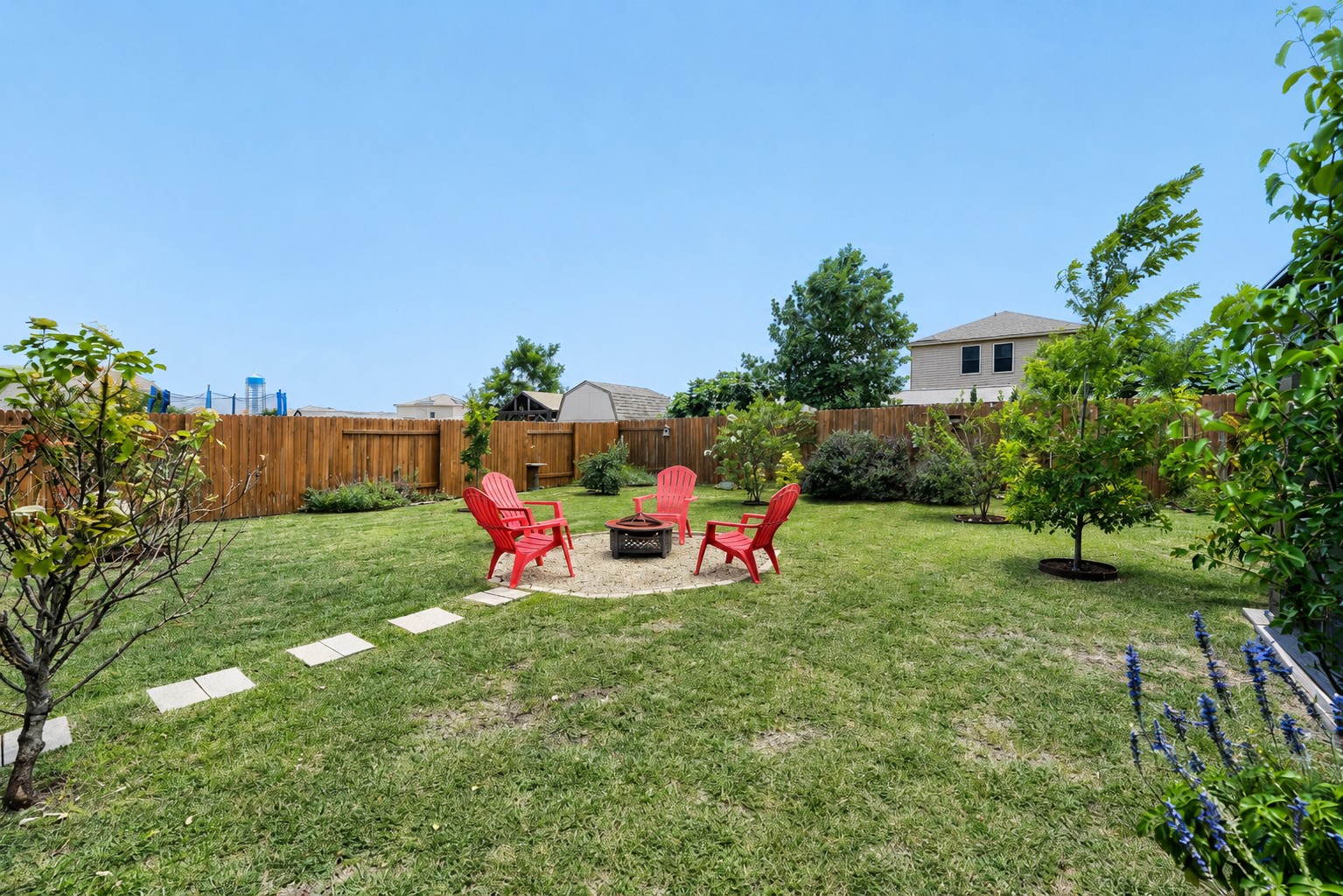 116 Millers Loop Jarrell, TX 76537 - Photo 20 of 23 Expansive backyard featuring a lush lawn and dedicated fire pit area—perfect for entertaining, relaxing, and making memories year-round.