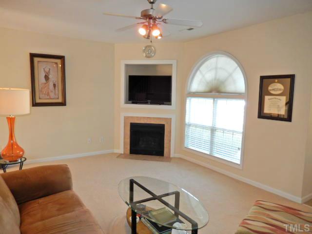 2131 Piney Brook Road, Unit 106 Raleigh, NC 27614 - Photo 4 of 23 a living room with furniture a fireplace and a flat screen tv