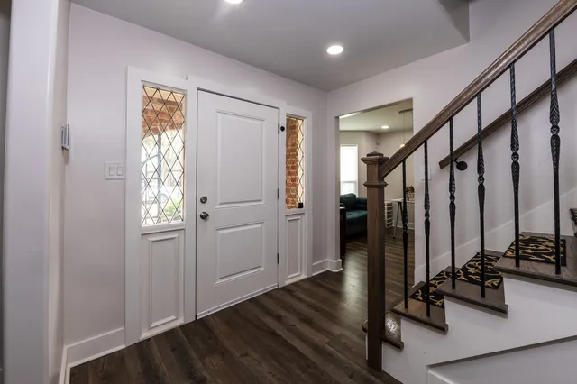 a view of a hallway with wooden floor and windows