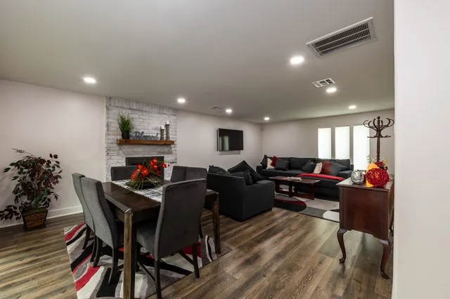 a living room with furniture a dining table and a potted plant