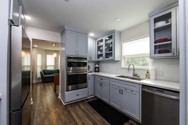 a kitchen with stainless steel appliances granite countertop white cabinets and a sink