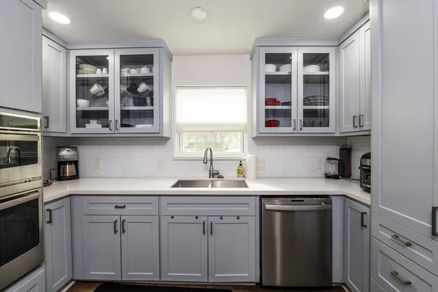 a kitchen with cabinets oven and a sink