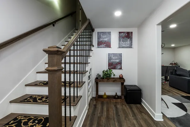 a view of a livingroom with a flesh screen tv and stairs