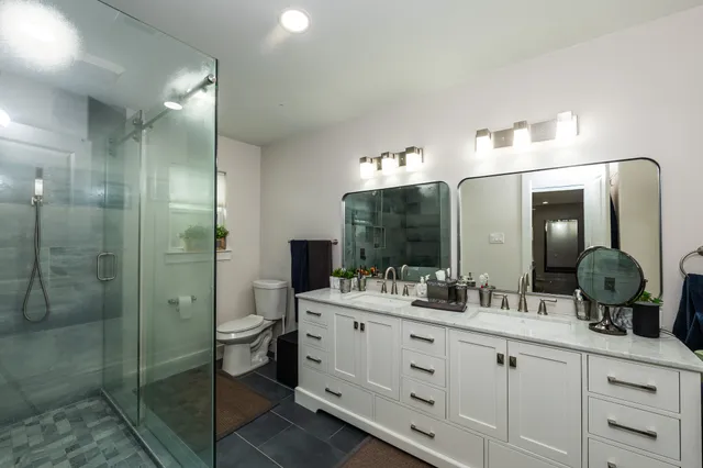 a bathroom with a sink a toilet and shower