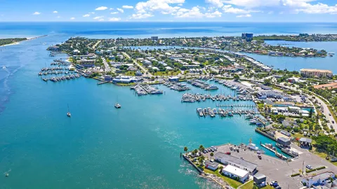 an aerial view of ocean and residential houses with outdoor space