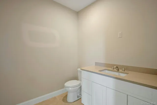 a bathroom with a granite countertop toilet and sink