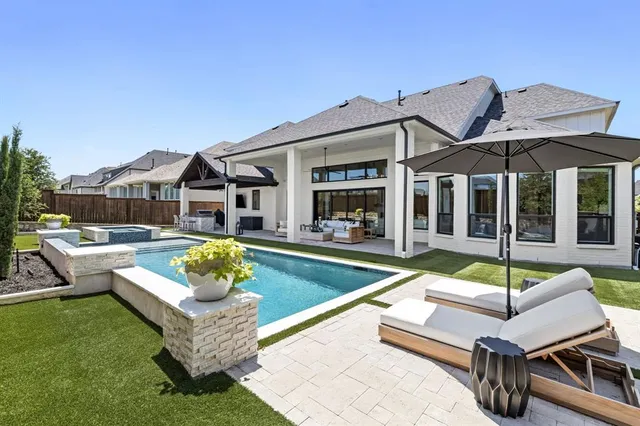 a view of a patio with couches table and chairs under an umbrella