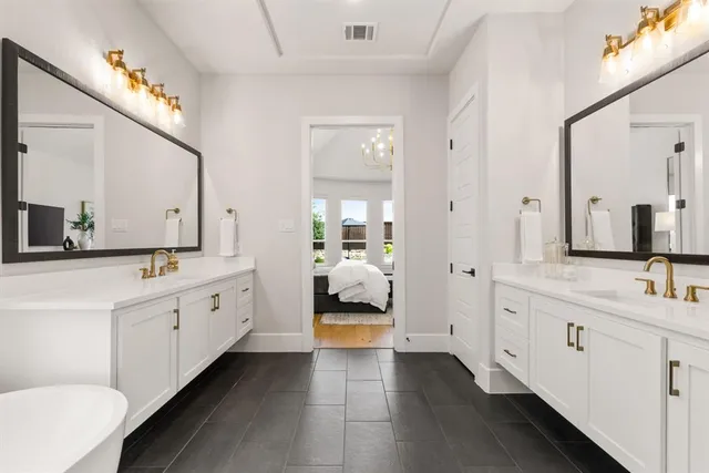 a spacious bathroom with double vanity and a large mirror