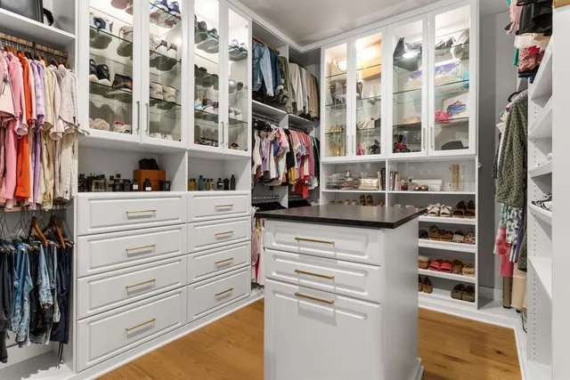 a view of walk in closet with clothes and shoes
