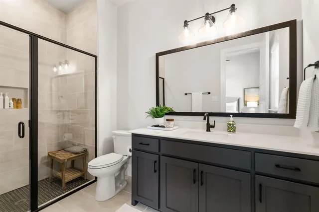 a bathroom with a toilet a sink a mirror and shower