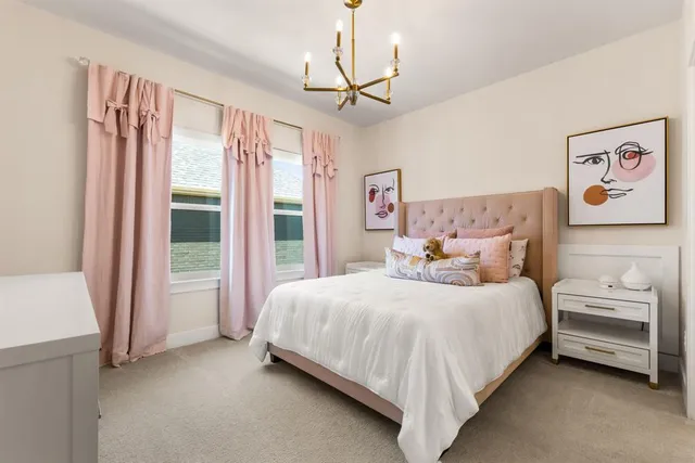 a bedroom with a bed painting and a large window