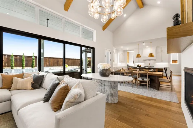 a living room with furniture a large window and a table