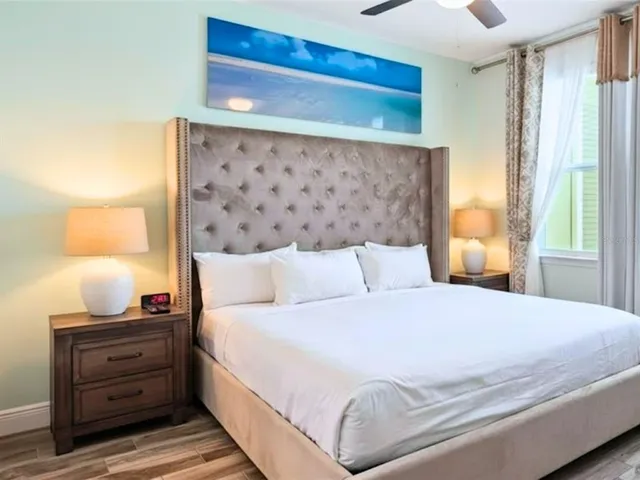 a bedroom with a bed and a lamp on dresser