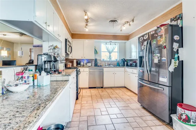 a kitchen with stainless steel appliances granite countertop a refrigerator and a sink