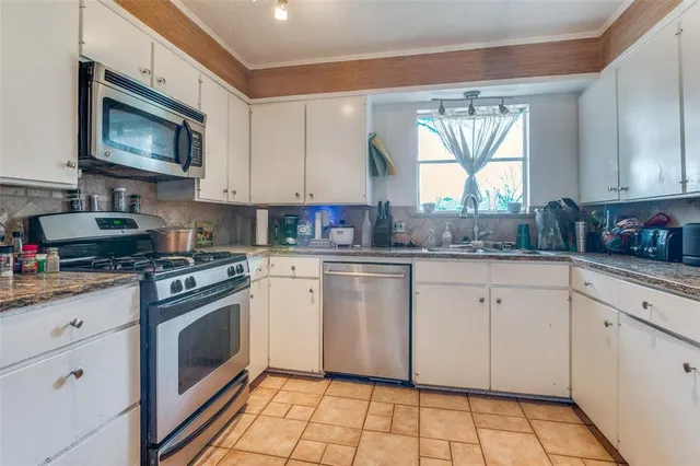 a kitchen with cabinets appliances and a window