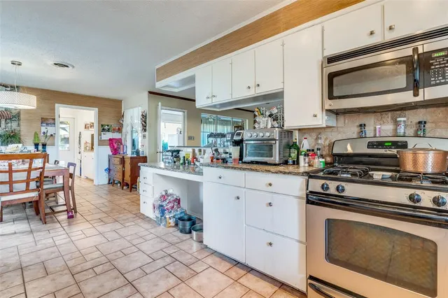 a kitchen with stainless steel appliances granite countertop a stove and cabinets