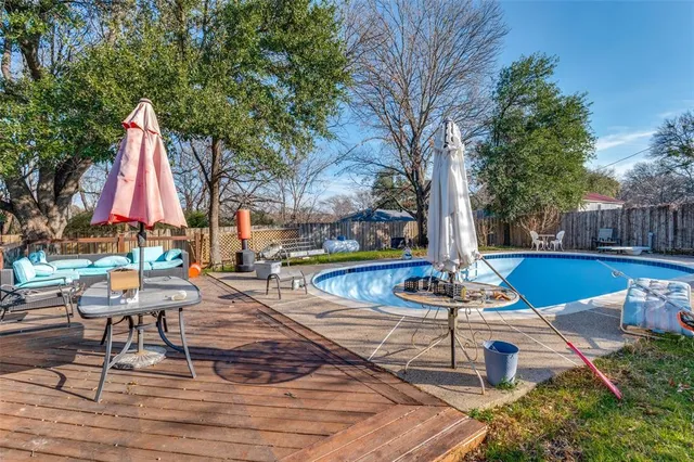 a view of backyard with swimming pool and sitting area