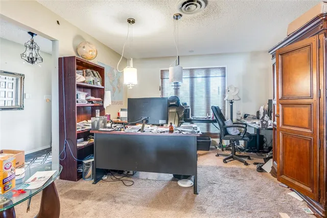 a view of a workspace with furniture and a window