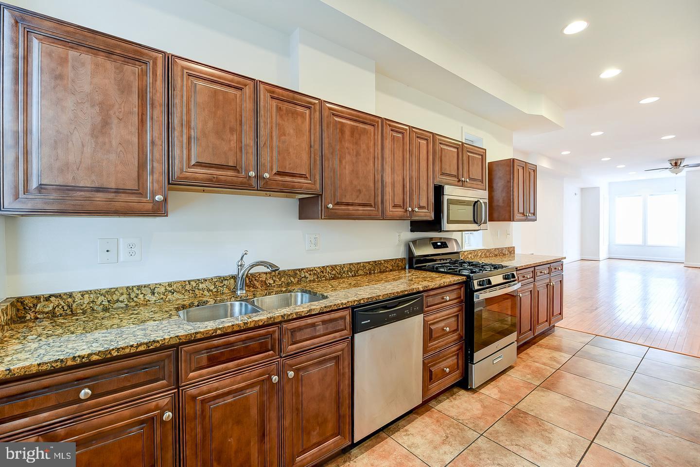 14 Florida Avenue Northeast Washington, DC 20002 - Photo 11 of 31 a kitchen with stainless steel appliances granite countertop a stove a sink and a microwave