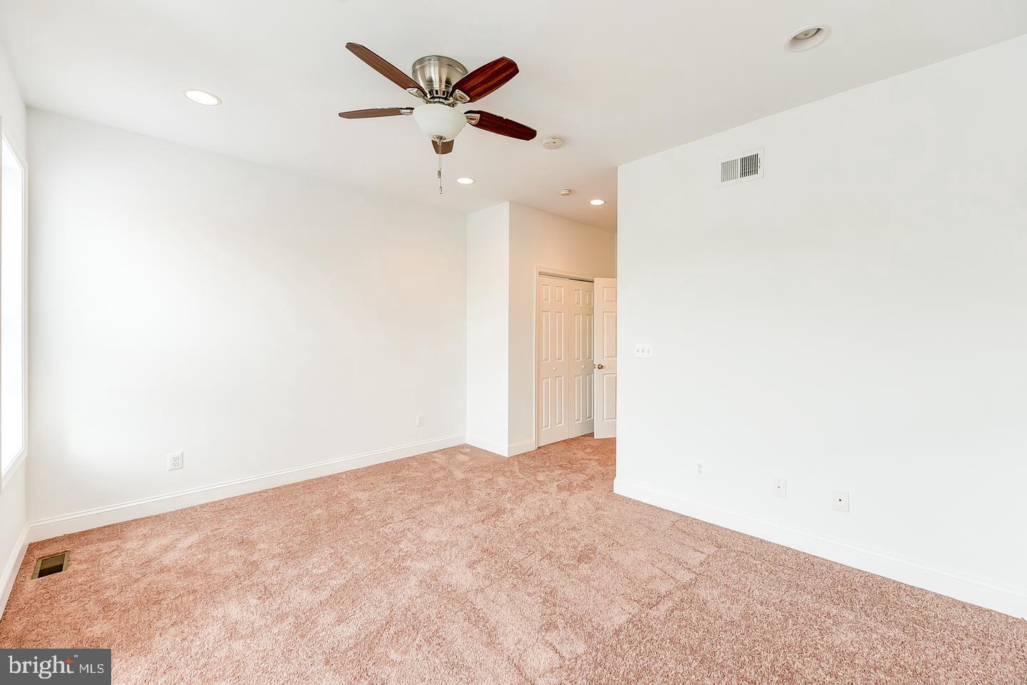 14 Florida Avenue Northeast Washington, DC 20002 - Photo 20 of 31 an empty room with a ceiling fan and a window