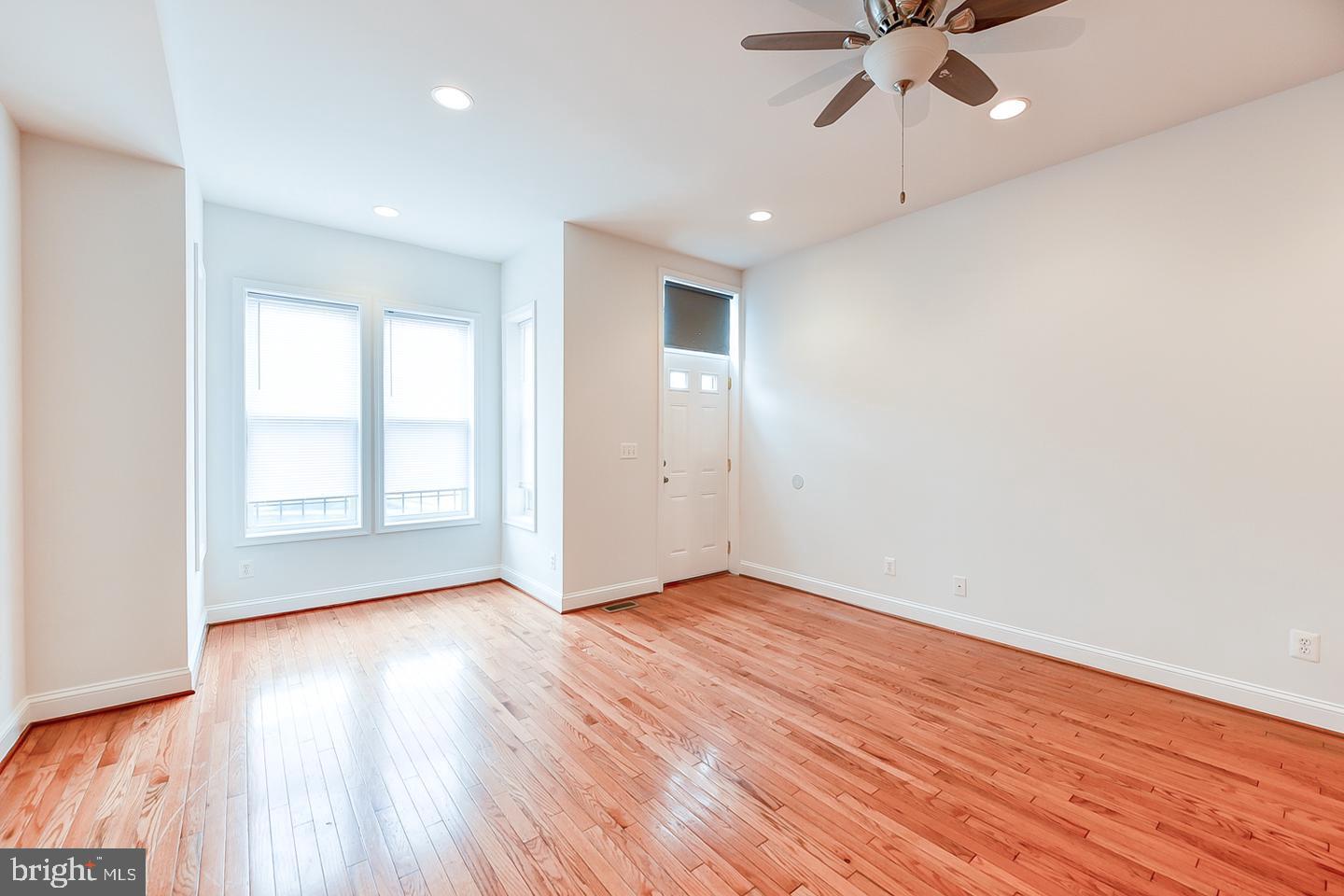 14 Florida Avenue Northeast Washington, DC 20002 - Photo 4 of 31 an empty room with wooden floor fan and windows