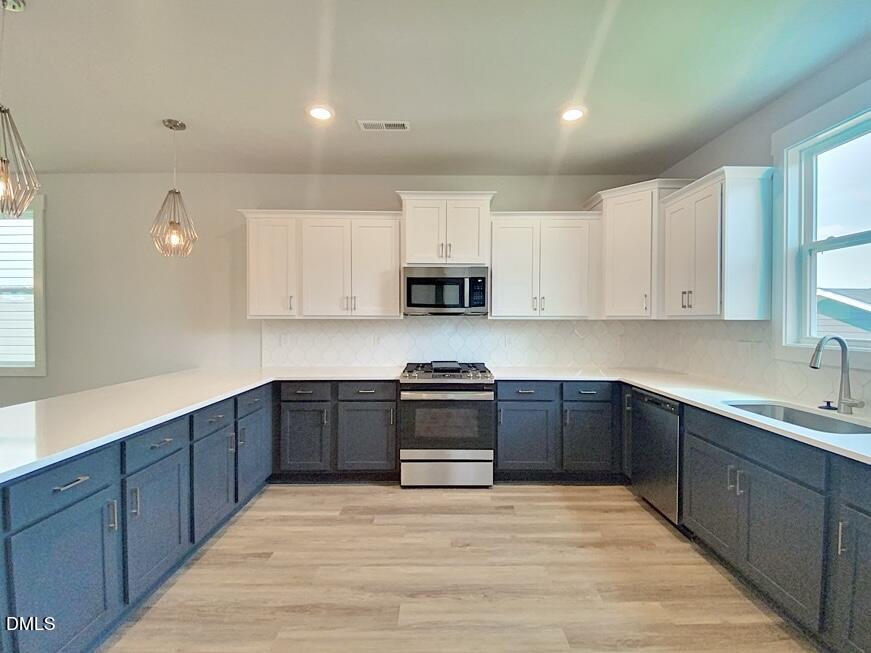 1309 Holding Village Way Wake Forest, NC 27587 - Photo 15 of 28 a kitchen with wooden cabinets and stainless steel appliances