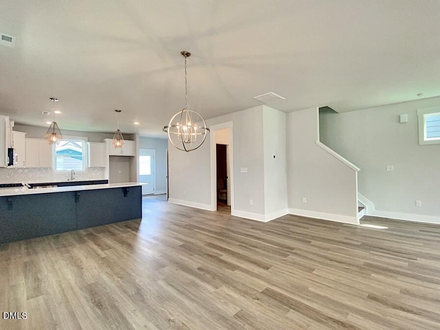 1309 Holding Village Way Wake Forest, NC 27587 - Photo 17 of 28 a view of a room with wooden floor and kitchen view
