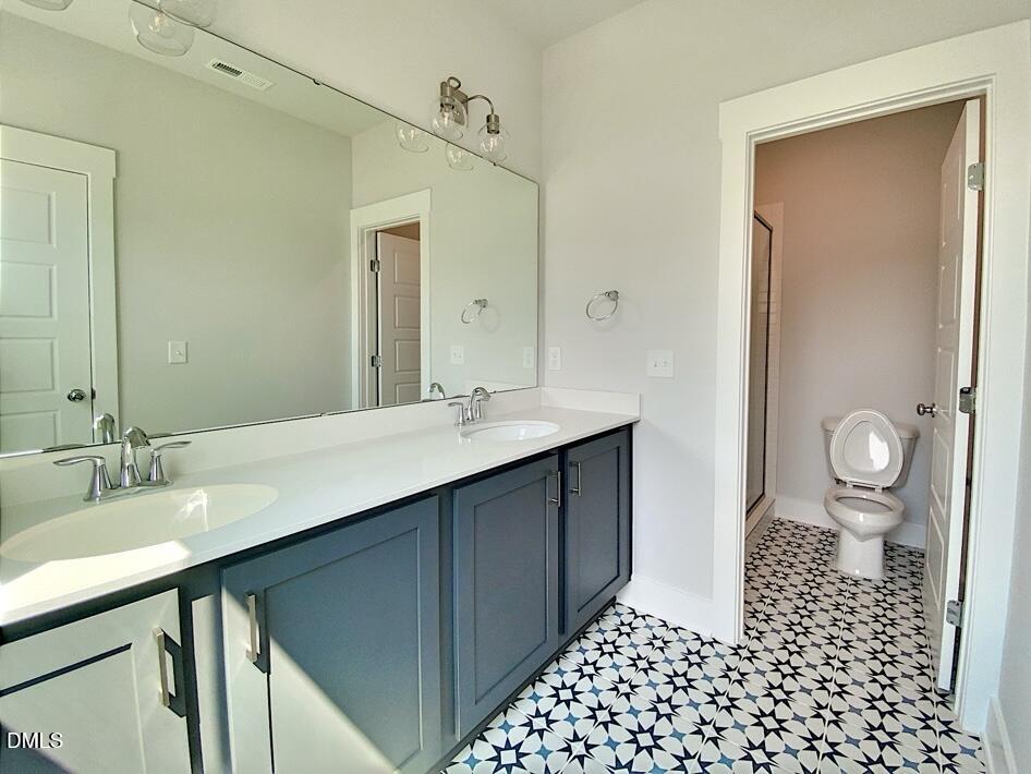 1309 Holding Village Way Wake Forest, NC 27587 - Photo 27 of 28 a bathroom with a sink a toilet a shower and a mirror
