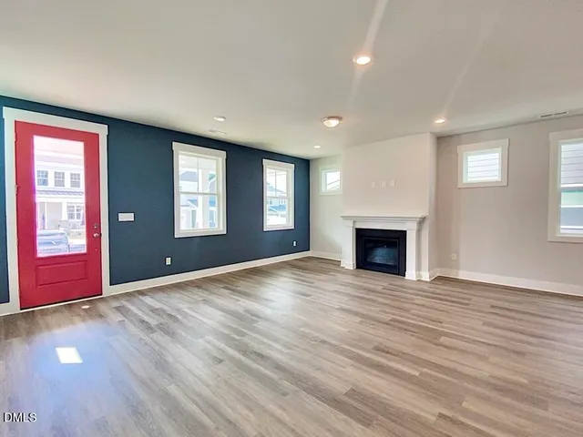 a view of empty room with wooden floor and fireplace