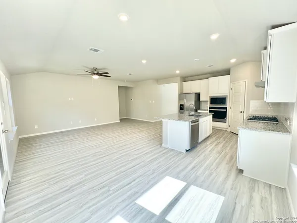 a view of kitchen with cabinets microwave and stove