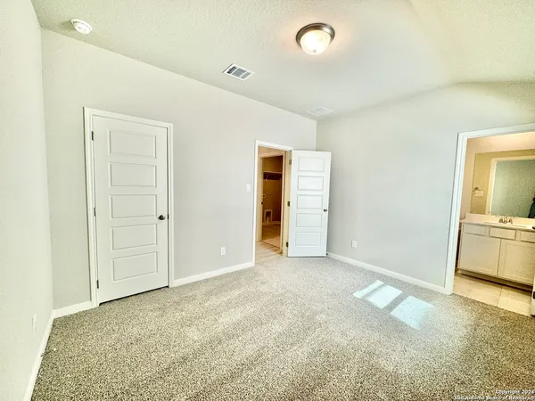 an empty room with cabinet and mirrors