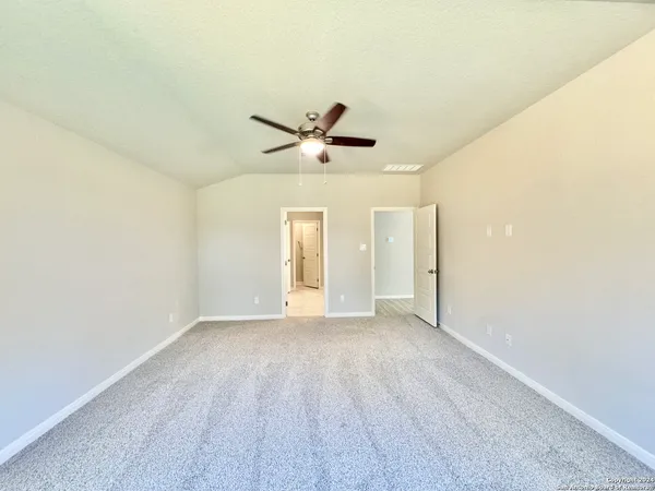 an empty room with a ceiling fan and wooden floor