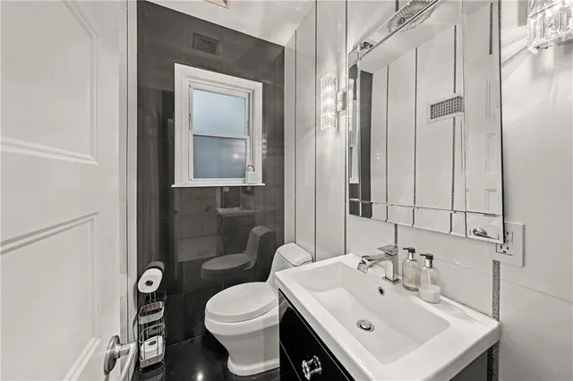 a bathroom with a toilet sink and mirror