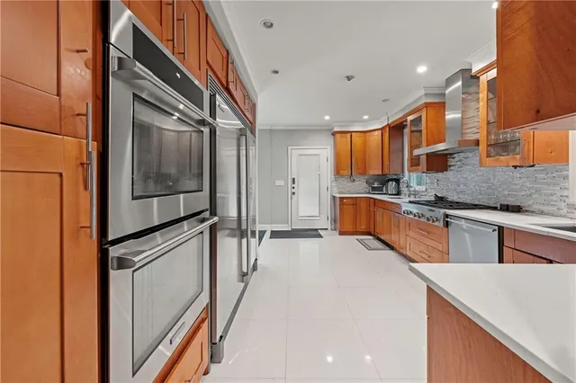 a kitchen with stainless steel appliances granite countertop a refrigerator a stove and a sink with wooden cabinets