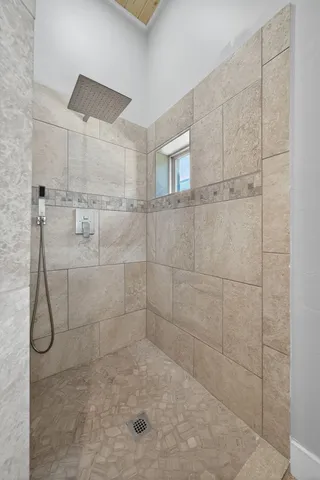 a roof deck with table and chairs and couches with wooden floor and fence